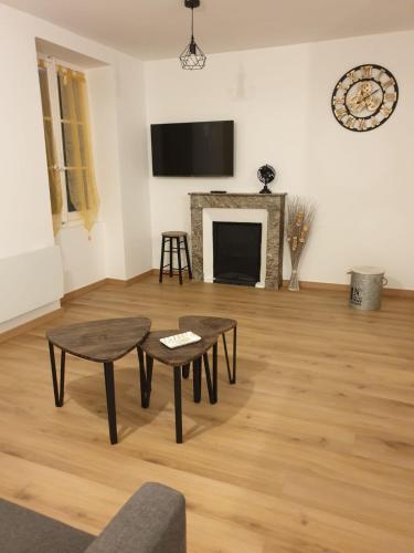 salon z dwoma stołami i kominkiem w obiekcie Appartement Dali centre historique Perpignan w Perpignanie