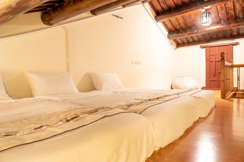 Cama grande en habitación con techo de madera en Kinmenhouse of Old Tiles No 4, en Jincheng