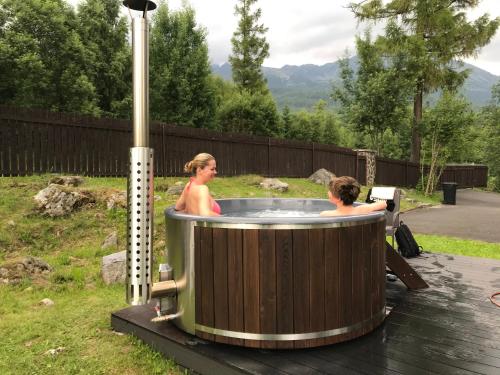 two people in a hot tub in a yard at Danielov dom in Vysoké Tatry