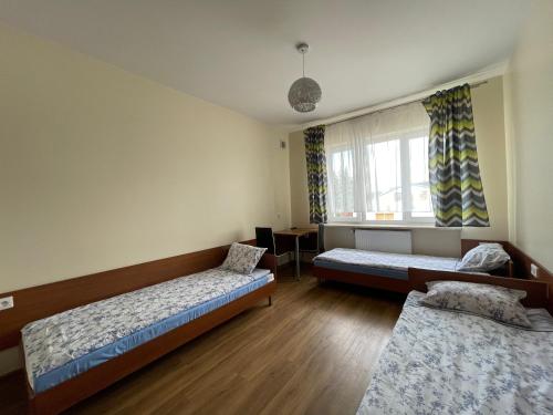 a room with two beds and a window at ANNA NOCLEGI in Raszyn