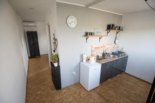 a kitchen with a sink and a clock on the wall at OPG Dokić in Kopačevo