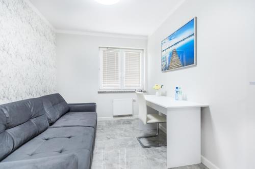 salon z kanapą i biurkiem w obiekcie Apartament Nawigator Giżycko/Wilkasy w mieście Wilkasy