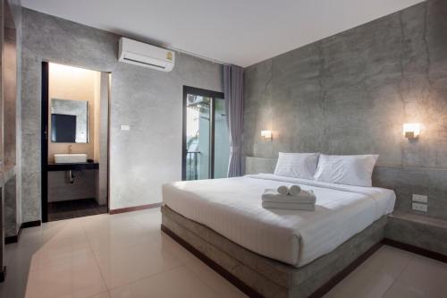 1 dormitorio con 1 cama blanca grande en una habitación en Ritsurin Boutique Hotel - โรงแรมริทสุริน บูติค, en Phuket