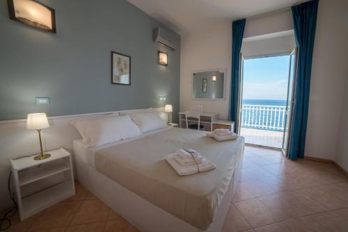 - une chambre avec un lit et une vue sur l'océan dans l'établissement Gatto Bianco Casalabate, à Casalabate