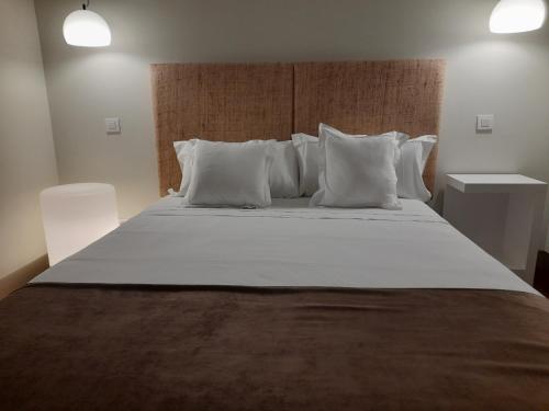 ein Schlafzimmer mit einem großen Bett mit weißen Kissen in der Unterkunft Hotel Ceres in Lerma