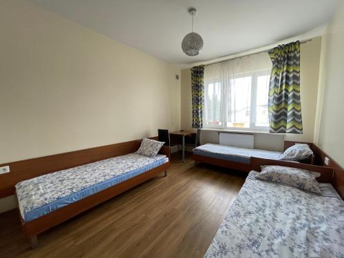 a room with two beds and a window at ANNA NOCLEGI in Raszyn