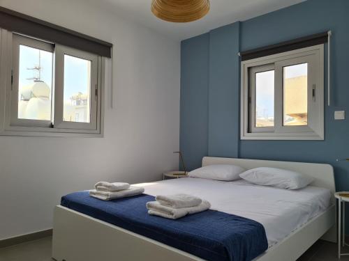 a bedroom with two towels on a bed with two windows at Tefkrou Anthia 9 apts in Ayia Napa