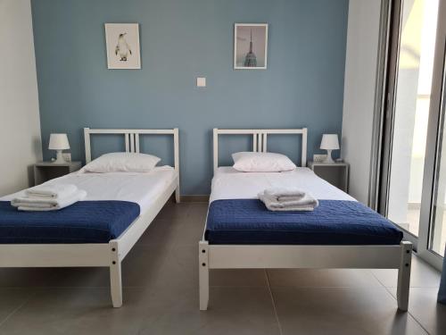 Tefkrou Anthia 9 apts في أيا نابا: سريران في غرفة ذات جدران زرقاء