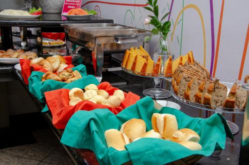 a buffet with various types of bread and pastries at Manferrari Hotel in Contagem