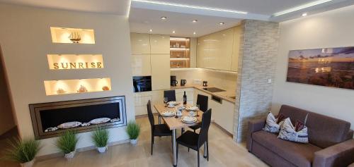 a living room with a table and a fireplace at Apartment Sunrise in Świnoujście