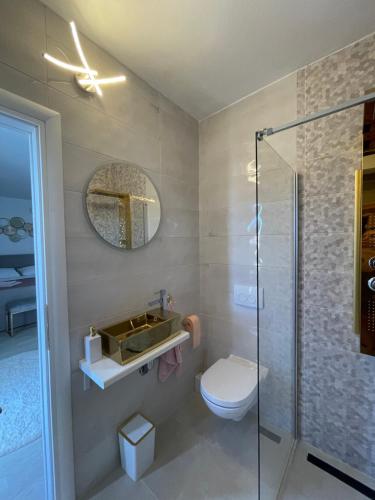 a bathroom with a toilet and a sink and a shower at Villa Eureka in Vodice