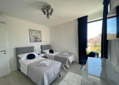 a hotel room with two beds and a window at Villa Eureka in Vodice