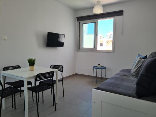 a bedroom with a bed and a table and chairs at Tefkrou Anthia 9 apts in Ayia Napa