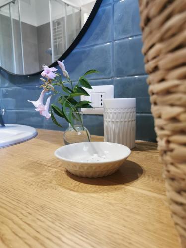 a bowl on a table with a vase with a flower at Domus Taura in Terracina