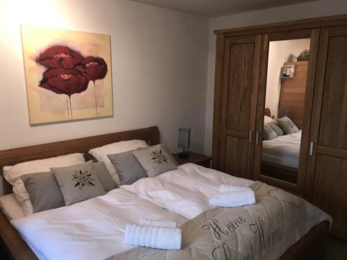 a bedroom with a bed with two pillows and a mirror at Golfchalet Uttlau in Bad Griesbach