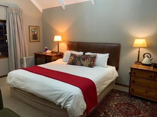 ein Schlafzimmer mit einem großen Bett mit einer roten Decke in der Unterkunft Critchley Hackle Dullstroom Towers in Dullstroom