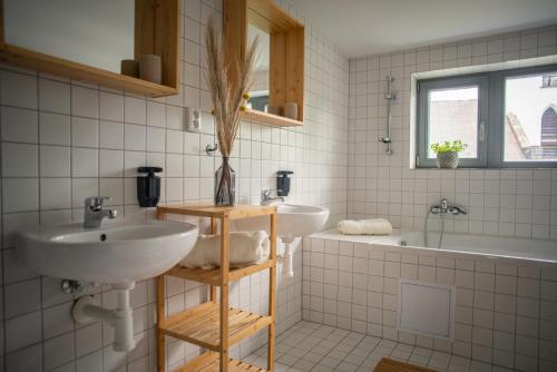 uma casa de banho com 2 lavatórios, uma banheira e um lavatório. em Stará Celnice Kvilda em Kvilda