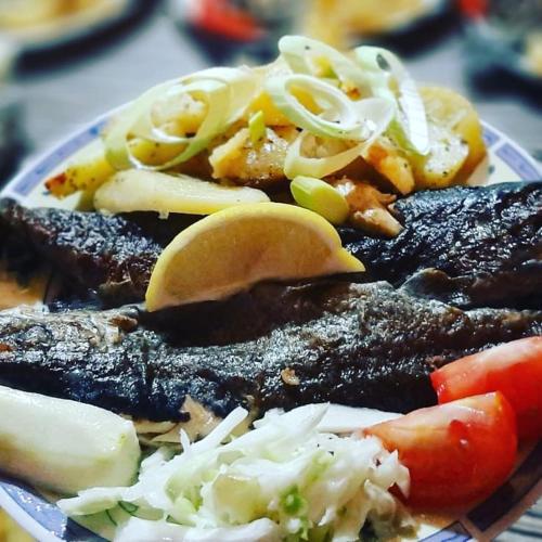a plate of food with meat and vegetables on it at Woden apartment in Žabljak