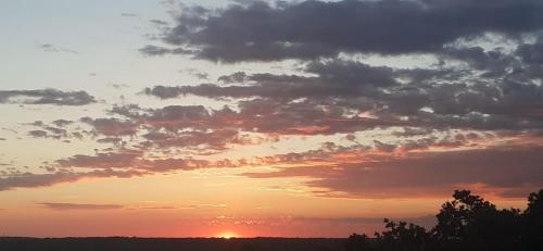 a sunset with the sun setting in the sky at Lennida Studio Apartman with free parking in Kavran