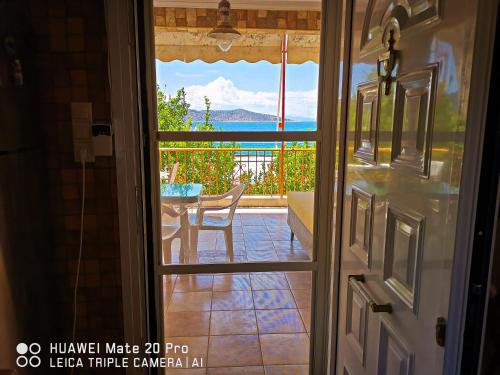 a door leading to a patio with a view of the ocean at Ξένιος Ζευς Ηλιακτής. Χώρος Χαλάρωσης & Ξεκούρασης in Áyios Yeóryios