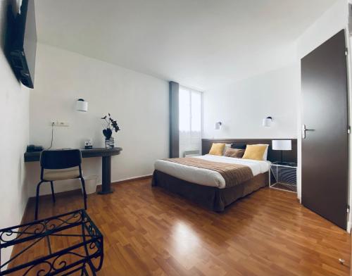 a bedroom with a bed and a desk and a chair at Hotel Air-lane in Saint-Léger-sous-Brienne