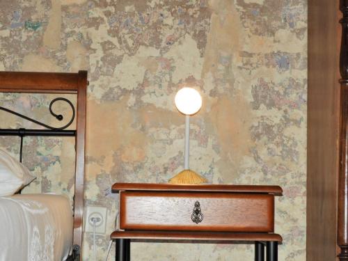 a bedroom with a table with a lamp on a wall at Zupan 1 - apartman in Krk
