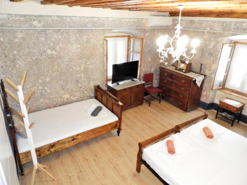a room with two beds and a desk and a tv at Zupan 1 - apartman in Krk