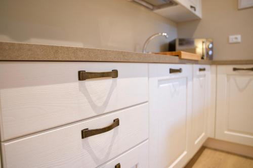 a kitchen with white cabinets and a counter top at Apt Bellagio DolceVita in Bellagio