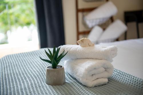a pile of towels and a plant on a bed at Sea Escape apartment in Chalkida
