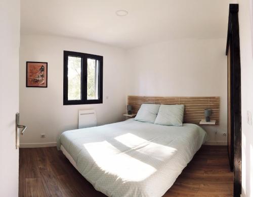 una camera da letto con un grande letto bianco e una finestra di Villa-jacuzzi-1chb-jardin-10minsAixEnPce-QuartierChic a Meyrargues