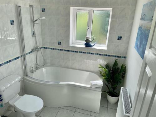 a bathroom with a tub and a toilet and a sink at Number 15 in Norwich