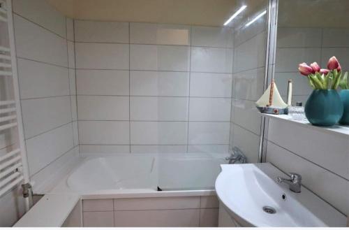 a white bathroom with a tub and a sink at Panorama apartment near Szeged Plaza in Szeged