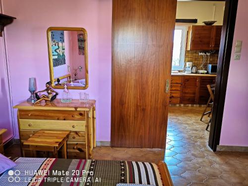 a bathroom with a dresser and a mirror on the wall at Ξένιος Ζευς Ηλιακτής. Χώρος Χαλάρωσης & Ξεκούρασης in Áyios Yeóryios