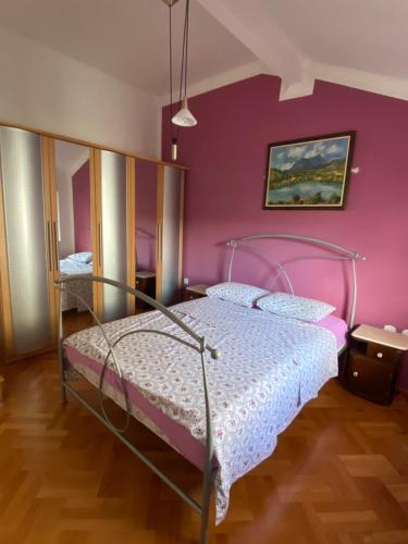 a bedroom with a bed with a pink wall at Gala Posh in Soko Banja