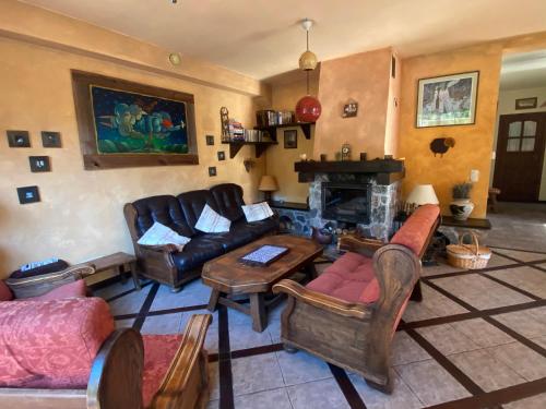 a living room with leather furniture and a fireplace at Szeroki Bór oaza w Puszczy z Sauną, Banią i Jacuzzi in Szeroki Bór