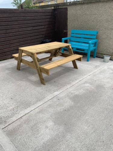 a wooden picnic table and a blue bench at Kathleen’s Haven in Causeway