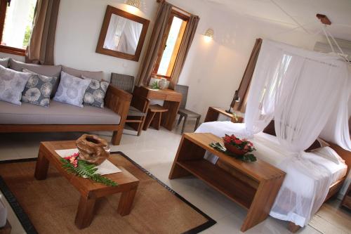 a living room with a couch and a table at Domaine Les Rochers in La Digue