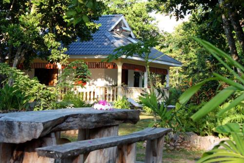 a house with a stone bench in front of it at Domaine Les Rochers in La Digue