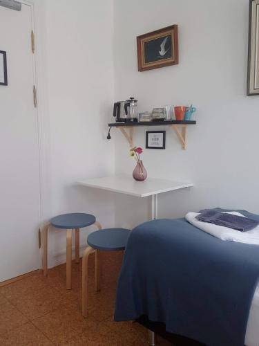 a bedroom with a bed and a table and two stools at Refurinn Reykjavik Guesthouse in Reykjavík