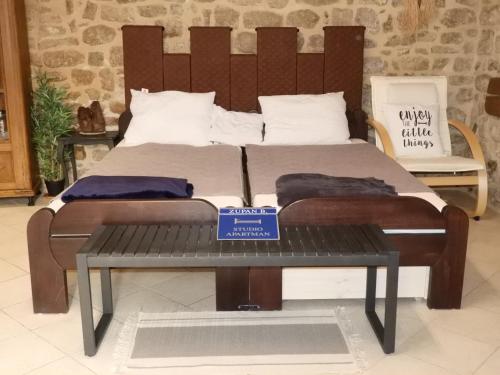 a bed with a sign on a bench in a room at Zupan B studio apartman Krk in Krk