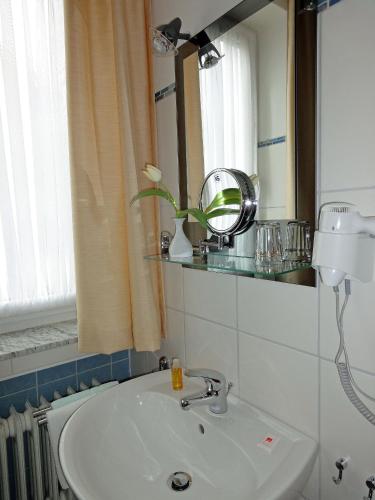 a bathroom with a sink and a mirror at Hotel Marienhof in Bad Wörishofen