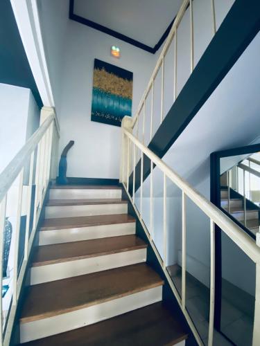 a staircase in a house with white and wood steps at Hotel Air-lane in Saint-Léger-sous-Brienne