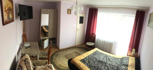 ブワディスワボボにあるPokoje Gościnne Szymonの小さなリビングルーム(ベッド1台、テーブル付)