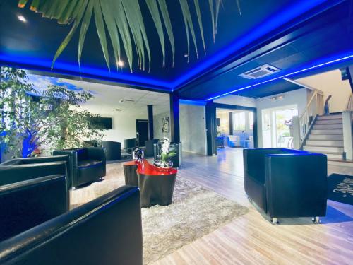 a lobby with blue ceilings and chairs and stairs at Hotel Air-lane in Saint-Léger-sous-Brienne