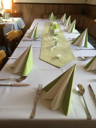 a long table with green napkins and forks and spoons at Gasthof zur Post in Siegen