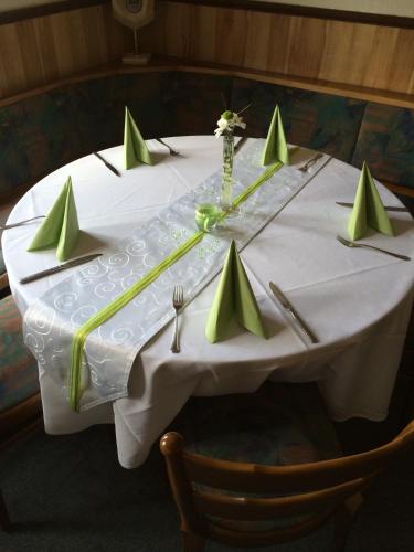 a table with a white table cloth and green napkins at Gasthof zur Post in Siegen