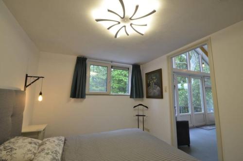 een slaapkamer met een bed en een klok aan het plafond bij DINOS - Whole guesthouse - Nearby Groningen and lake in Eelderwolde