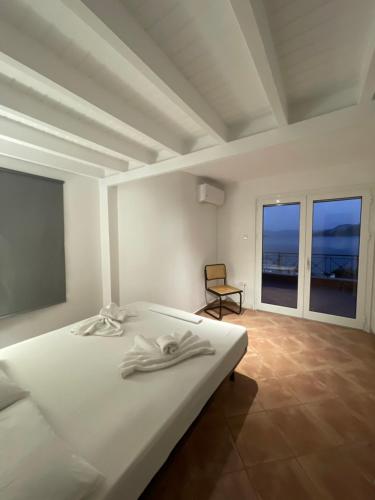 a white bedroom with a bed and a chair at Amazing view family house! in Kapótidhes