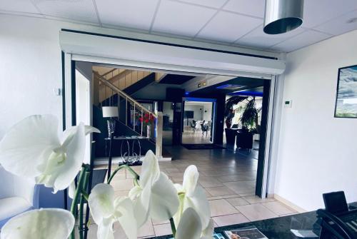 a lobby with a glass door with white flowers at Hotel Air-lane in Saint-Léger-sous-Brienne