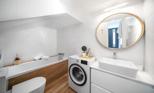 baño blanco con lavadora y espejo en Villa Gray, en Tribunj